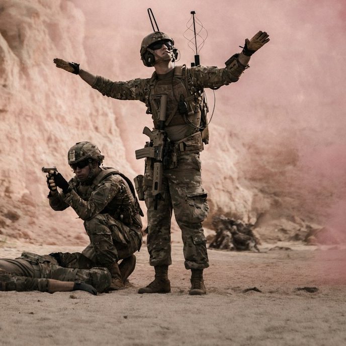 BU für Soldaten Soldaten in militärischer Ausrüstung während einer Übung in einer staubigen Umgebung zur Berufsunfähigkeitsversicherung