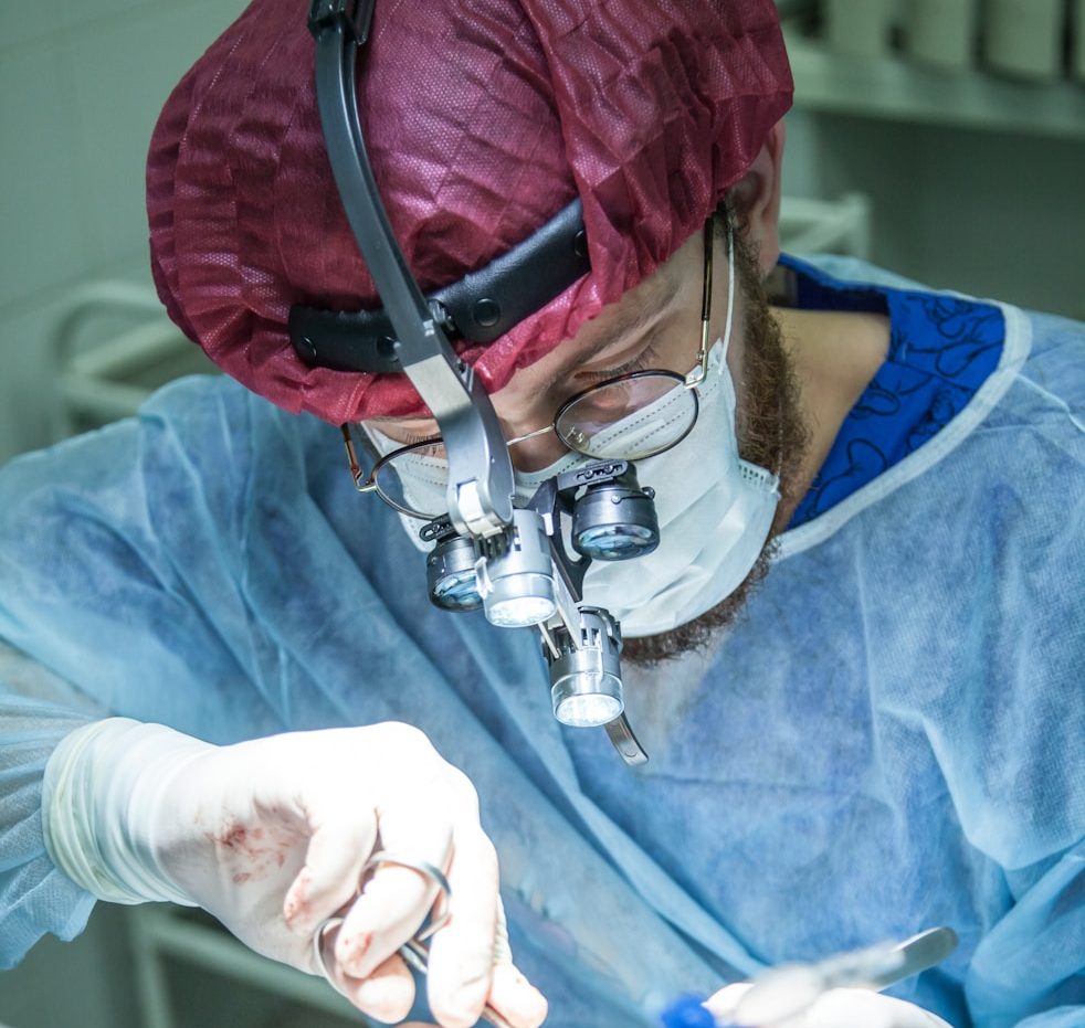 BU für Ärzte und Mediziner Ein Chirurg führt einen präzisen Eingriff durch, trägt eine chirurgische Maske und Kappe. BU für Ärzte und Mediziner