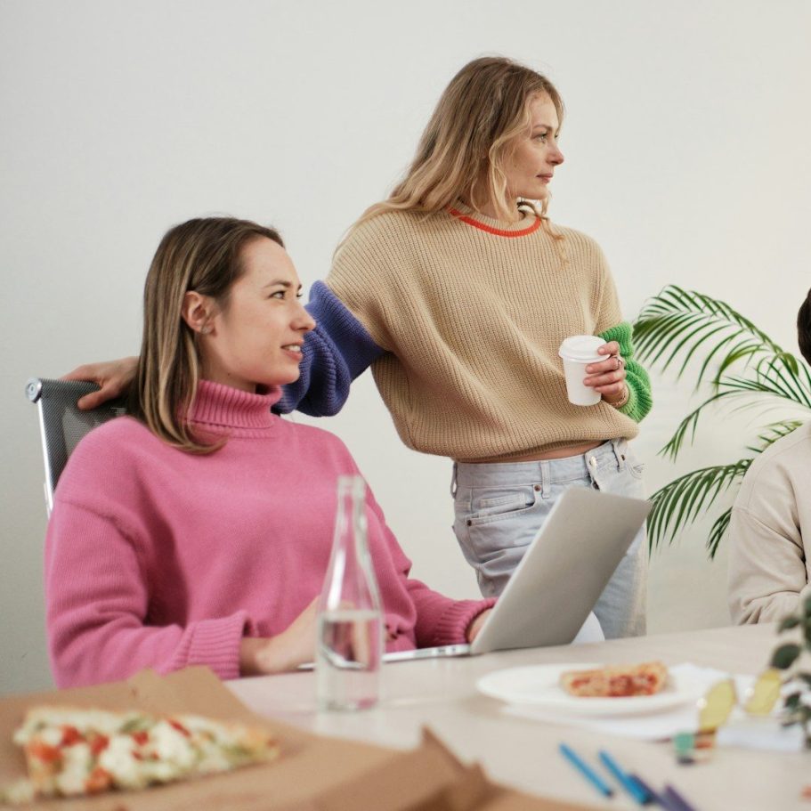 Angestellte und BU Drei Personen in einem Besprechungsraum, beschäftigt mit Notizen und Getränken zur Berufsunfähigkeitsversicherung